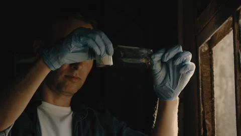 Man in blue plastic gloves examining sticky tape at a window Stock Footage 275706526