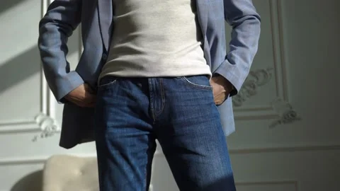 A man in a blue suit, jeans, puts one hand in his pocket, posit Stock Footage 152473963