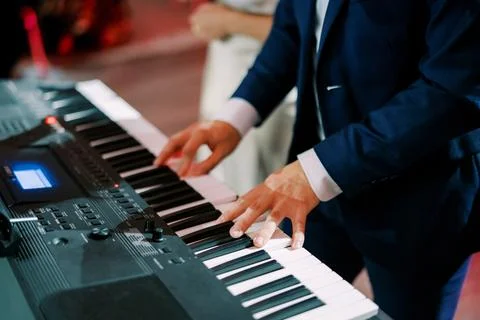 Man in blue suit playing electronic keyboard Stock Photos