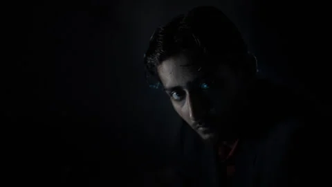 A man in a blue suit sitting in a creative lighting set Stock Footage 251767050