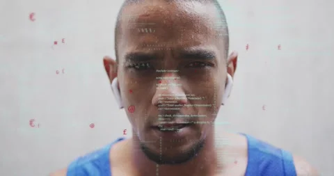 Man in blue tank, sweating and focusing, earbuds activating scrolling code Stock Footage 334178819