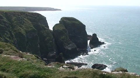 Man in blue walks past in front of the cliff Stock Footage 33846046