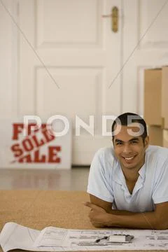 Man with blueprints in new house Stock Photos