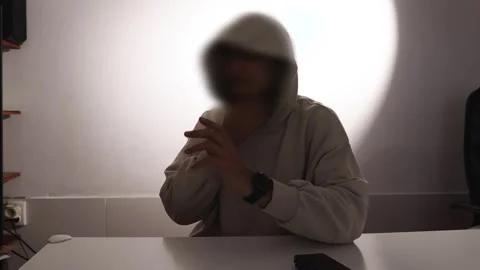 A man with a blurred face gives an interview Stock Footage 276869960