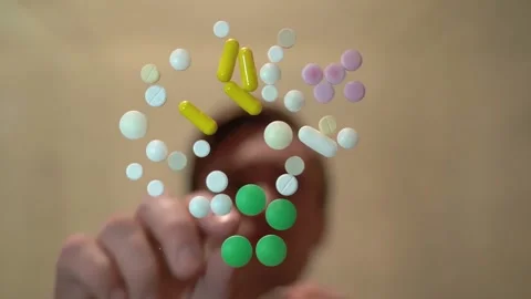 A man on a blurry background takes one white pill on a table and drinks Stock Footage 130190238