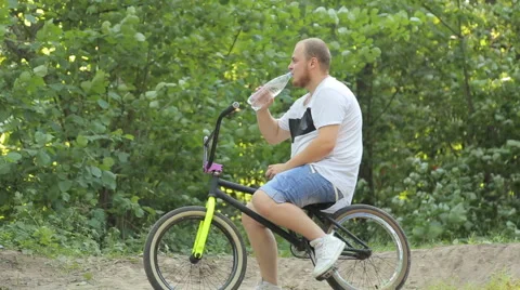 Man on bmx in the woods drinking clean water Stock Footage 65310768