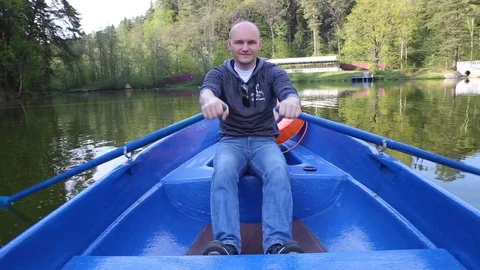 A man in a boat rowing paddles Stock Footage 70292967