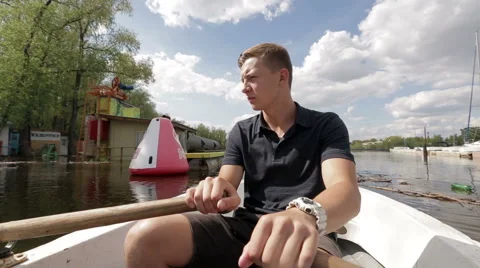 Man in the boat rowing on the pond. Stock Footage 54025924