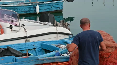 Man on a boat setting up fishing nets. Stock Footage 203957331