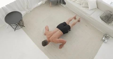 Man bodybuilder is doing push-ups exercises on workout at home on carpet. Stock Footage 143849644