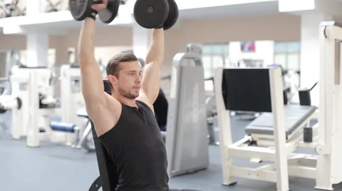 Man bodybuilder execute exercise with dumbbells in gym. Stock Footage 62561981