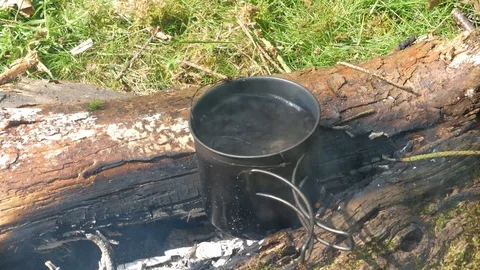 Man Boils Water on Campfire in Forest Woods, Campfire Burning Stock Footage 112672017
