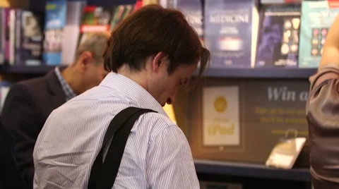 Man in a bookshop or library reading books Stock Footage 56370953