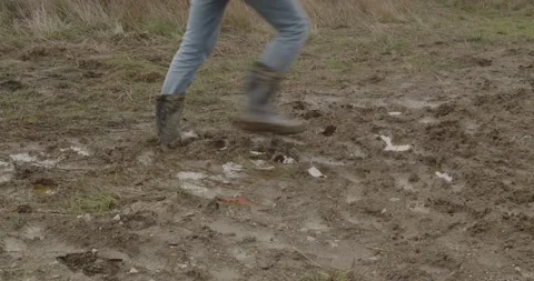 Man in boots moving through mud Stock Footage 260061741