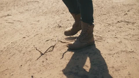 A man in boots stands in the desert, close-up Stock Footage 322797827
