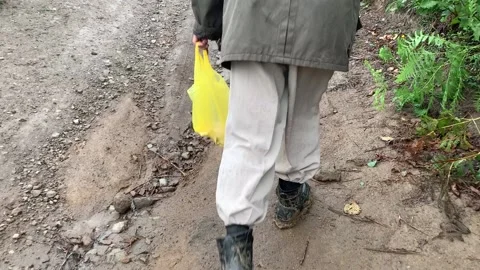 A man in boots walks through the mud Stock Footage 153070555