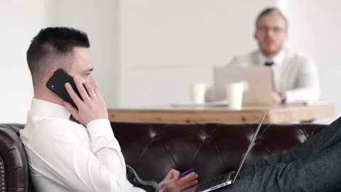 Man boss sitting on sofa and negotiating on phone. business call. talking to 스톡 동영상 133220940