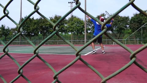 Man bouncing ball before serving on tennis court 動画素材 206993621