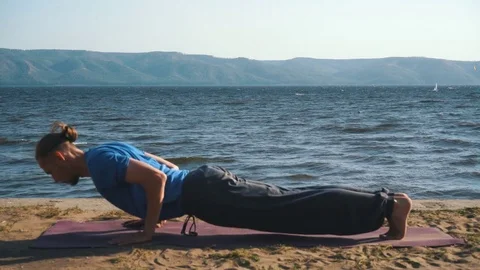 The man in the bow pose in yoga on the background of the river Stock Footage 80793448
