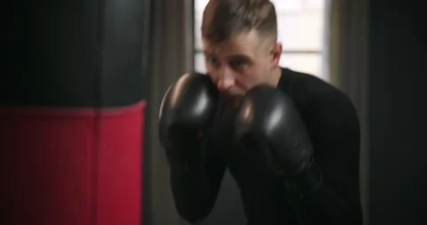 A man boxer beats a punching bag. Boxer practicing punches Stock Footage 145693230