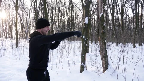 A man is boxing in the winter forest. Boxes in the nature. Stock Footage 87921139