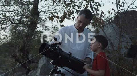 Man with boy using telescope Stock Photos