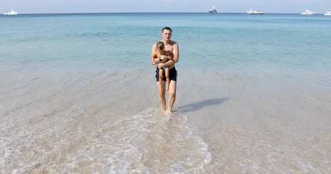 Man with boy walking on seashore Video stock 103715810