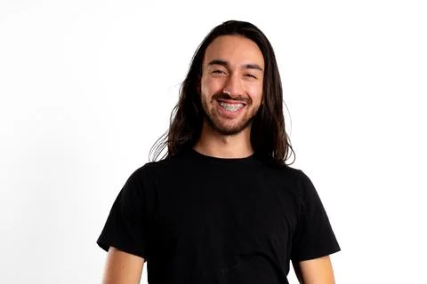Man with braces smiling at camera in white studio Stock Photos