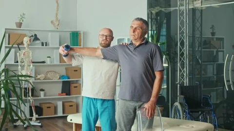 Man a Brain Stroke Doing Dumbbell Exercises as Part of a Rehabilitation Program Stock Footage 163550704