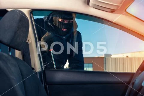 Man breaking into car using screwdriver Stock Photos