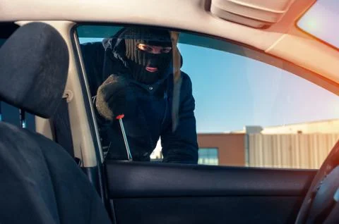 Man breaking into car using screwdriver Stock Photos