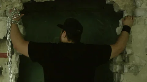 Man breaking free from chains in a dark room Stock Footage 304945300