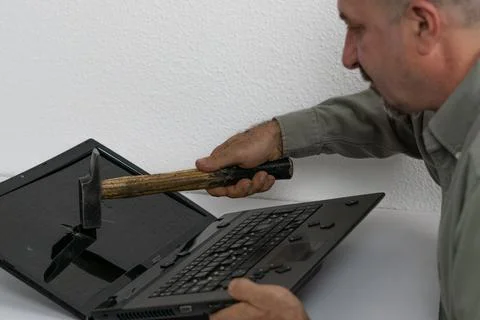Man breaking pc with hammer Stock Photos