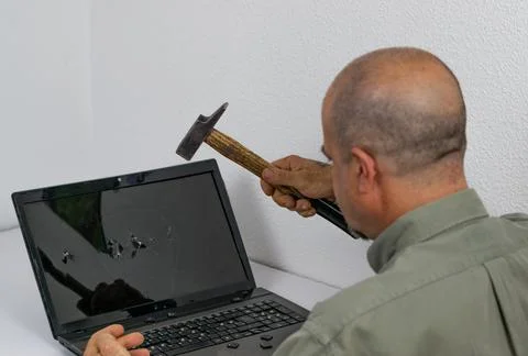 Man breaking pc with hammer Stock Photos