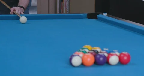 Man Breaking Racked Pool Balls in Eight-Ball Formation on Blue Billiards Table 库存影片 88226928