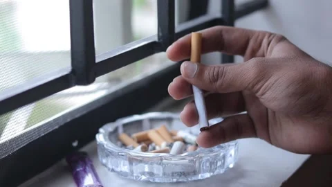 Man breaks a cigarette in to ash tray and quits smoking 스톡 동영상 231014608