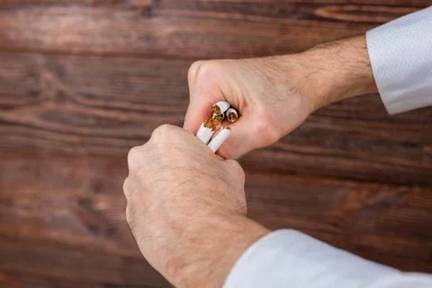 Man breaks cigarettes in his hands. Quit smoking. Concept. Stock Photos