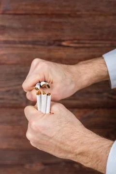Man breaks cigarettes in his hands. Quit smoking. Concept. Photos