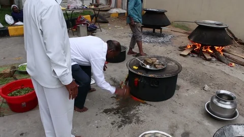 Man-breaks-coconut-and-prays-after-temple-food-cooked Stock Footage 93397079