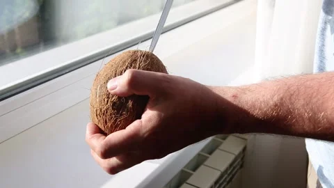 Man breaks coconut, to drink refreshing sweet coconut milk, exotic fruit Stock Footage 136089754
