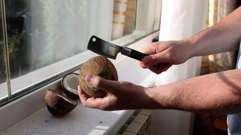 Man breaks coconut, to drink refreshing sweet coconut milk, exotic fruit Stock Footage 136089867
