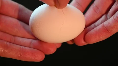 Man breaks an egg on a black Stock Footage 119369823