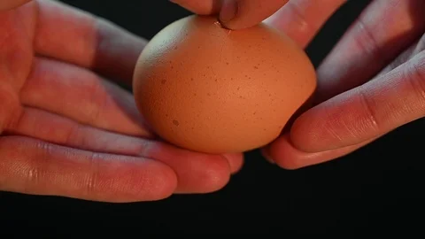 Man breaks an egg on a black Stock Footage 119369946