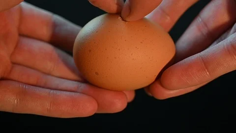Man breaks an egg on a black Stock Footage 119372125