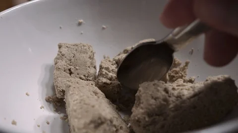A man breaks halva with a spoon into small pieces Stock Footage 102224770
