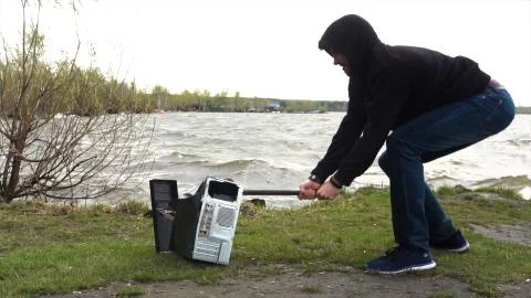 Man breaks a hammer system unit computer. Man with a sledge hammer and destroys 스톡 사진