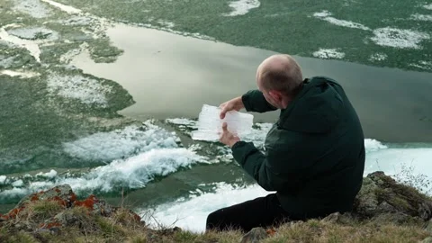 A man breaks a piece of crystal clear ice on the shore of a lake. Video stock 333206270