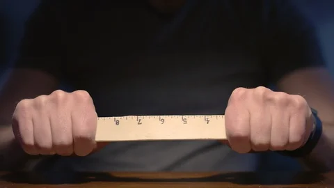 Man Breaks Ruler in Half While Sitting at a Desk 4K Stock-Footage 87098305
