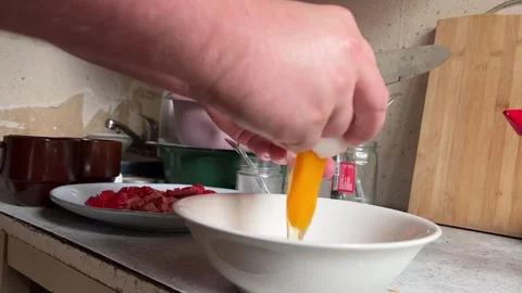 A man breaks a white chicken egg into a bowl Video stock 276871471