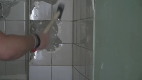 Man breaks white tiles with a hammer 스톡 동영상 160597936